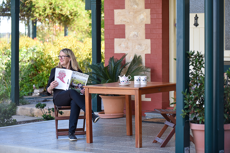 Woman sitting outside with wineries magazine 